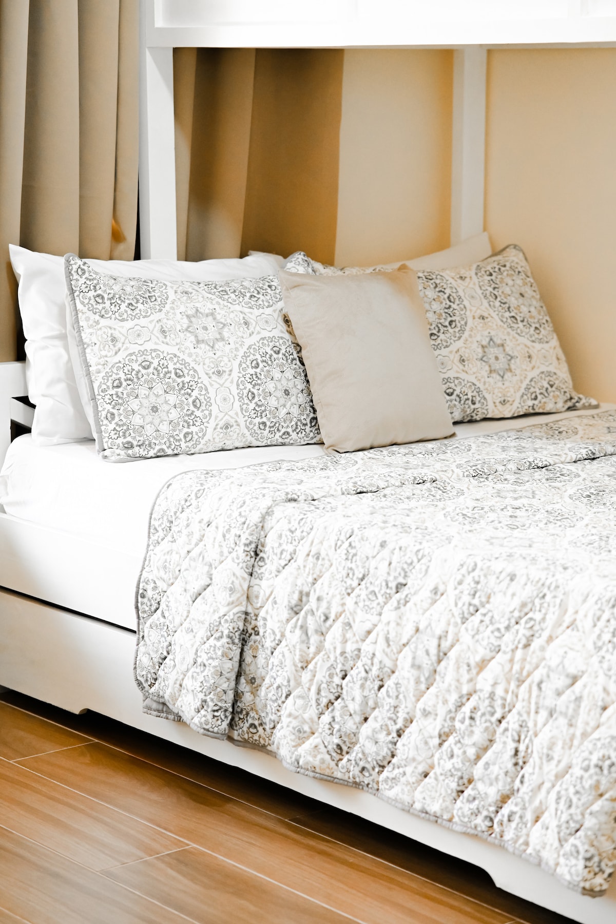Comfortable bedroom with patterned quilted bedding